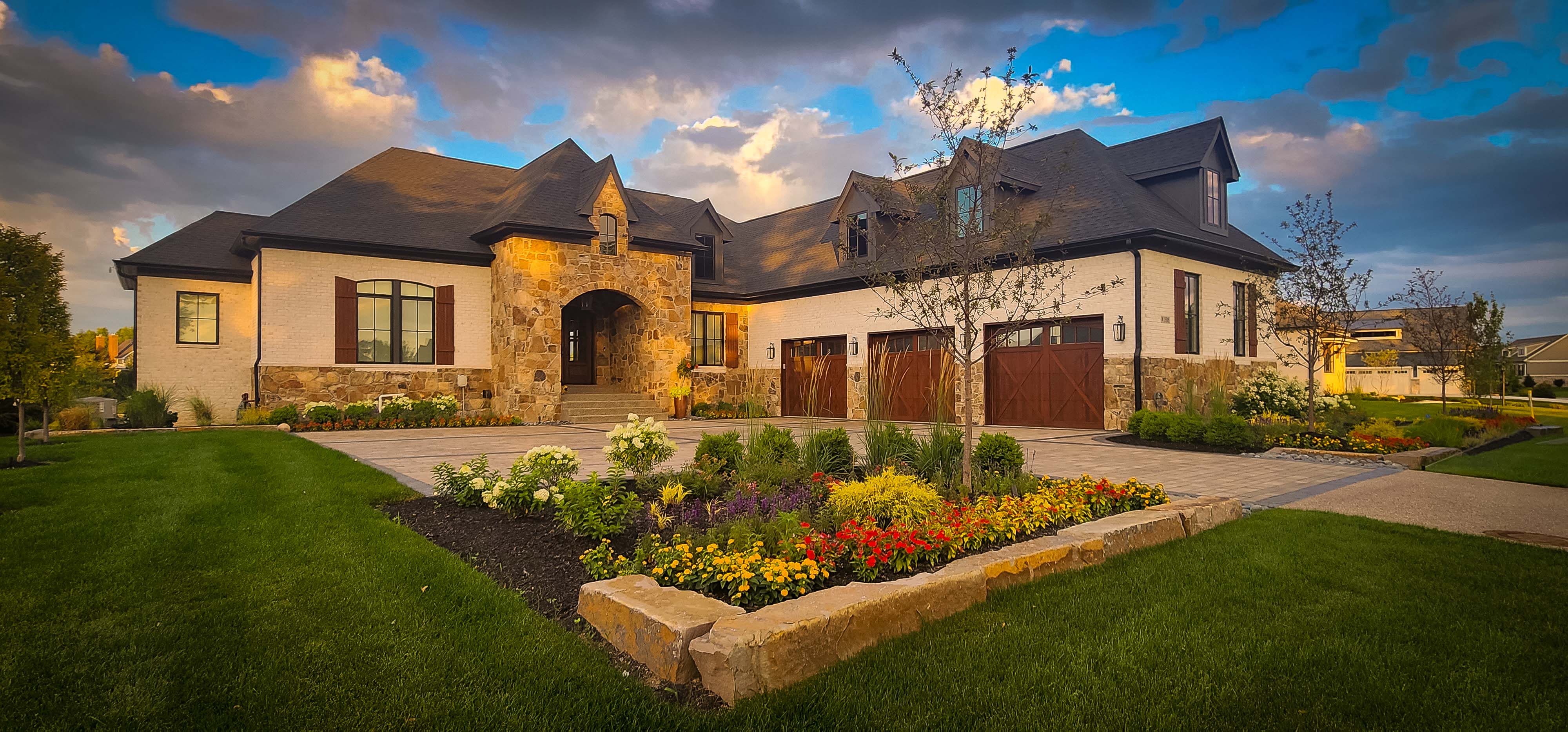 Natural stone home with colorful landscape plantings